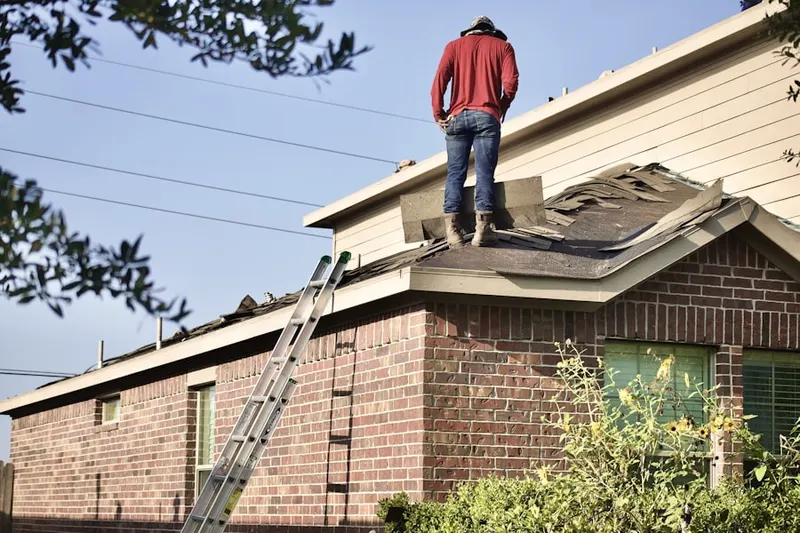 Professional roofer working on a residential roof in Linden Hall